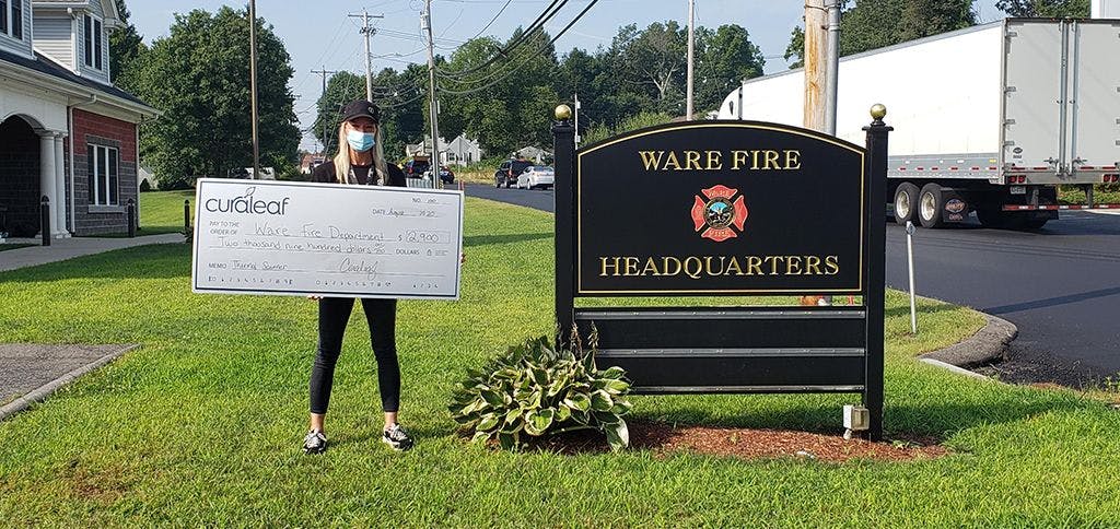 Curaleaf Ware employee standing in front of Ware Fire Headquarters
