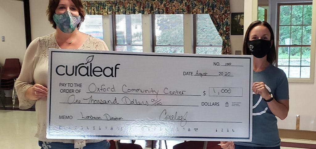Curaleaf Oxford manager hands check to Oxford Community Center