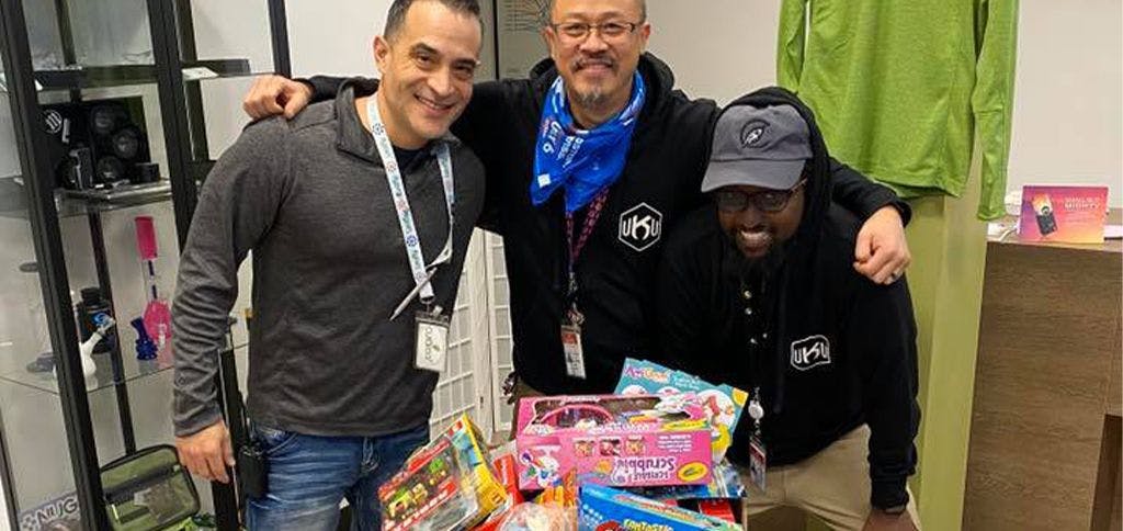 Our Takoma Park employees smiling next to all of the toy donations collected